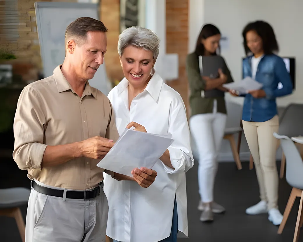 Consultor e cliente analisando documentos de um plano
